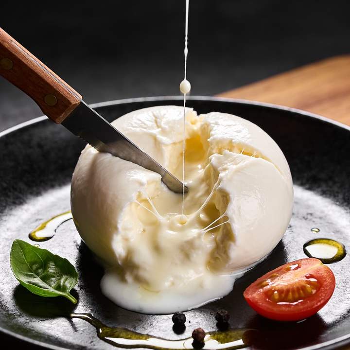 A burrata cut open on a dark plate, one variant of an Ad Multiplier batch